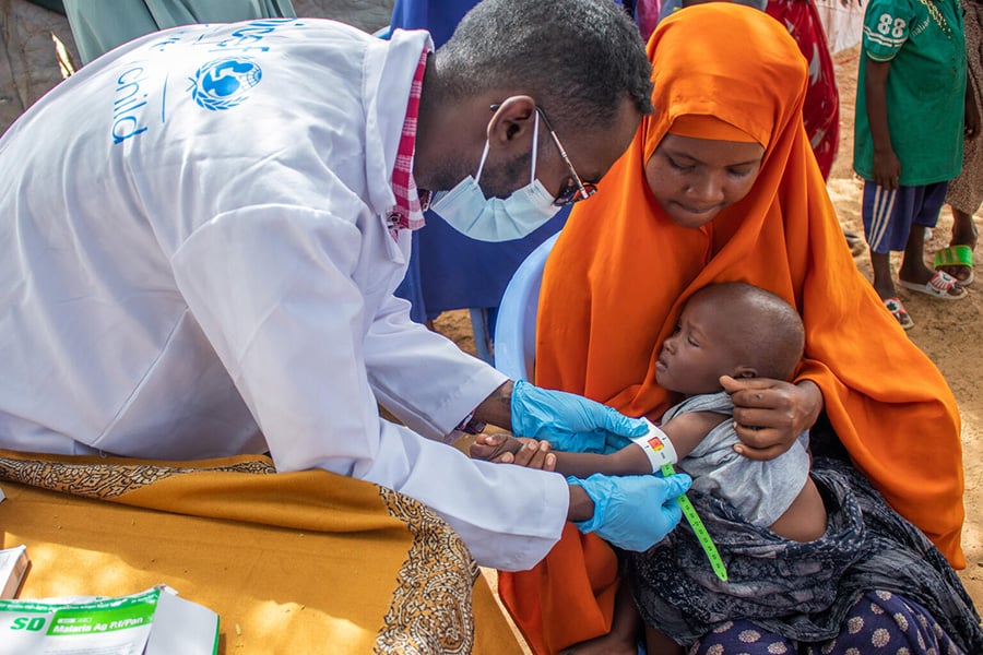 In Somalia untersucht ein Gesundheitshelfer ein Kind auf Mangelernährung. Mit Spezial-Maßbändern kann Mangelernährung schnell erkannt werden. Mit den Bändern können Eltern den Gesundheitszustand ihrer Kinder auch zu Hause kontrollieren.