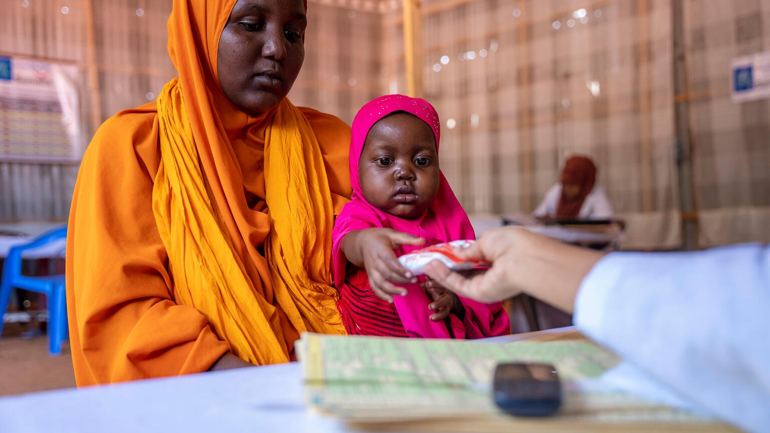  Erdnusspaste: Eine Helferin übergibt die Spezialnahrung in Somalia an eine Mutter und ihr Kind.
