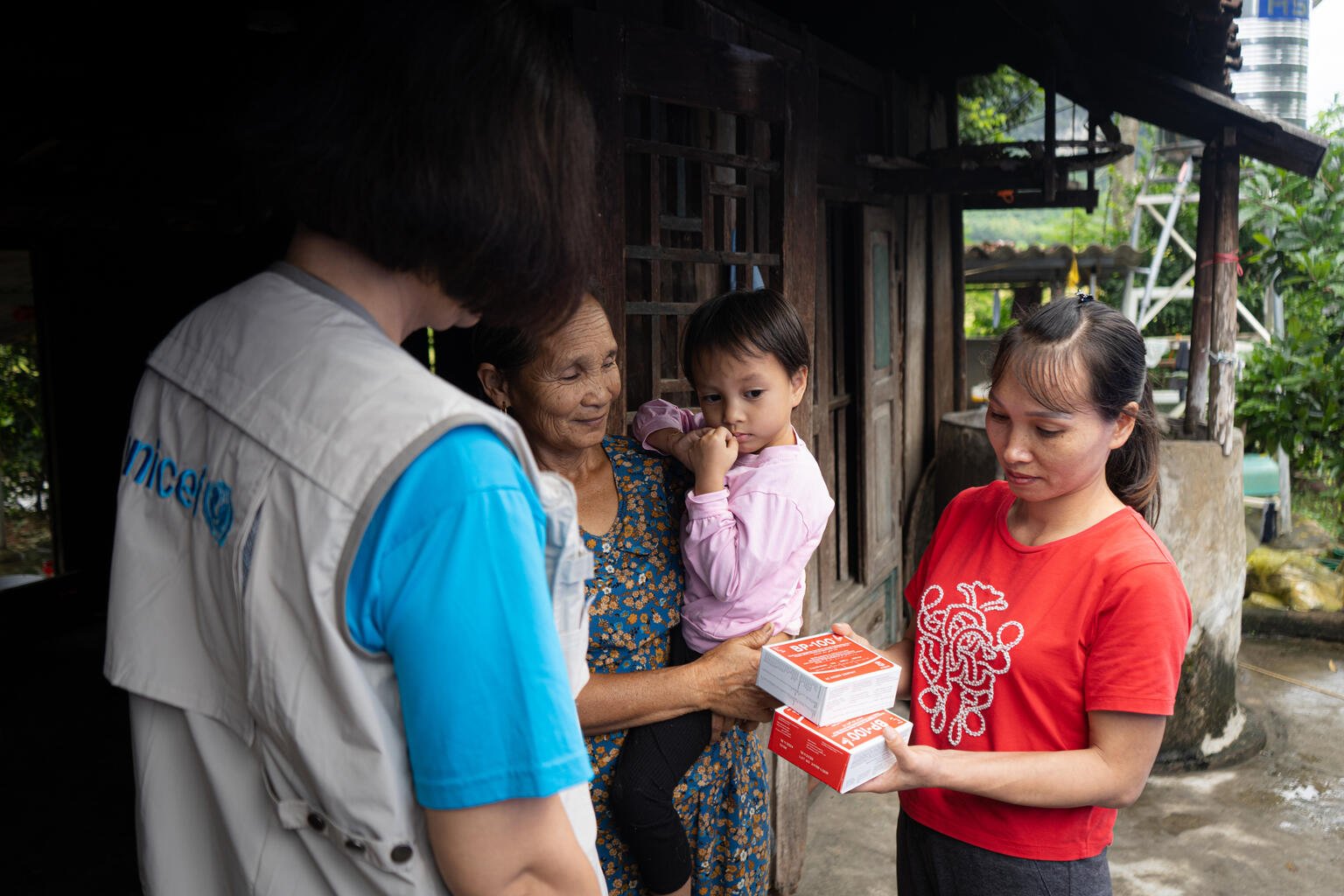 Vietnam: Eine UNICEF-Helferin übergibt Erdnusspaste an eine Familie