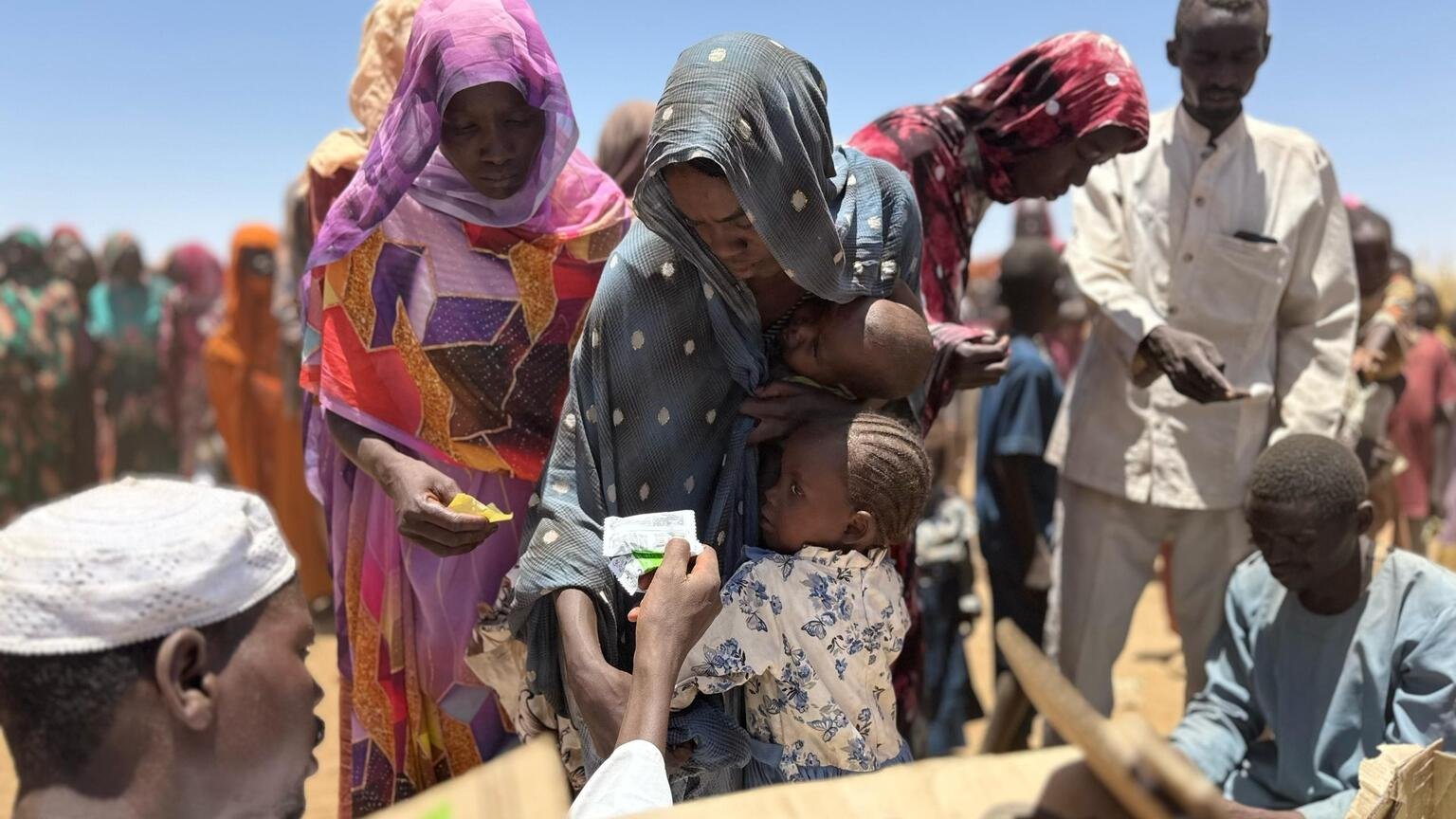 Eltern und Betreuer im Lager Zamzam in Nord-Darfur erhalten Hilfsgüter und Unterstützung von UNICEF.