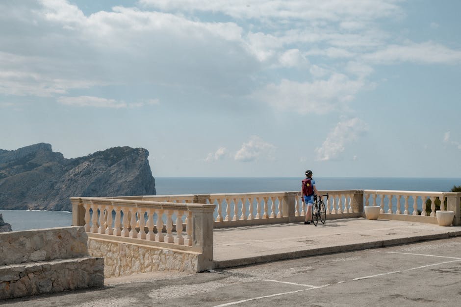 Cyclist taking in the breathtaking view at Mirador Es Colomer, Mallorca, Balearic Islands.