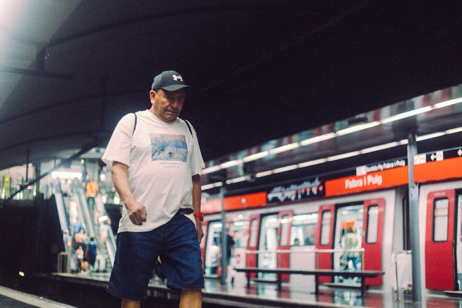 Man walks casually in a modern subway station wearing casual attire.