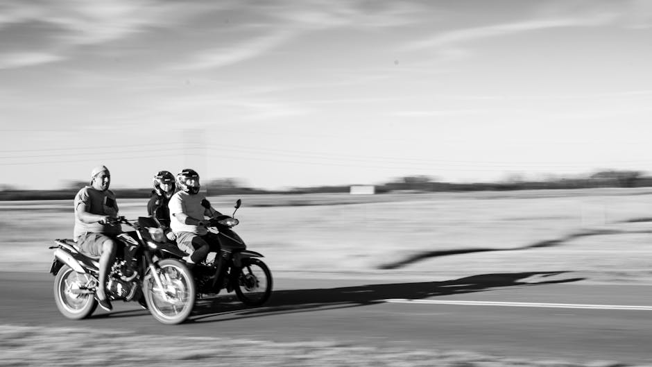 Three motorcyclists speeding through the countryside of Tomas Jofre, Argentina in black and white.