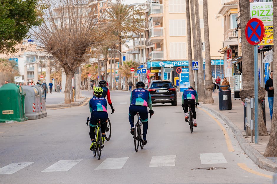 Cyclists ride through an urban street in Palma, Mallorca on a sunny day.