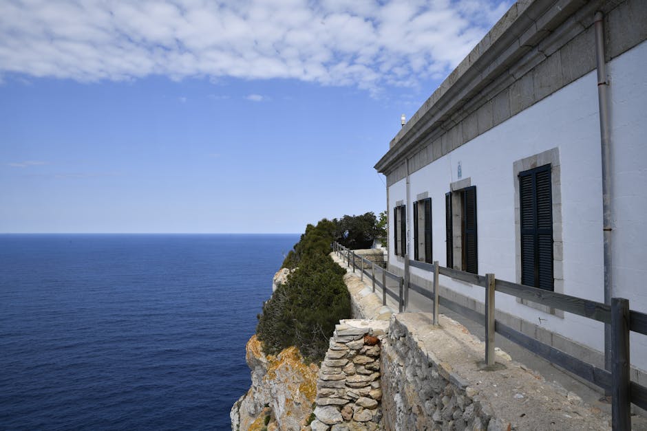 Explore the stunning coastal views of Mallorca with a lighthouse perched on rugged cliffs against a vibrant blue sea.