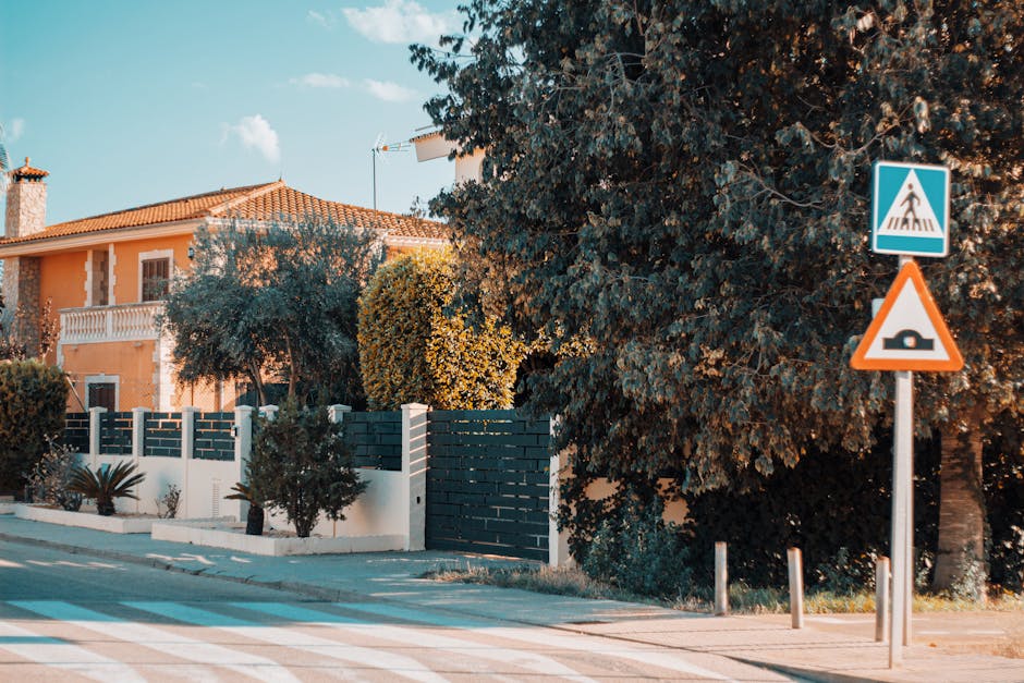 Beautiful Mediterranean style house in Mallorca with lush greenery and street signs under a bright sky.