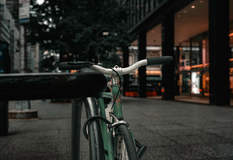 A close-up view of a bicycle locked to a post on a downtown street in New York City.