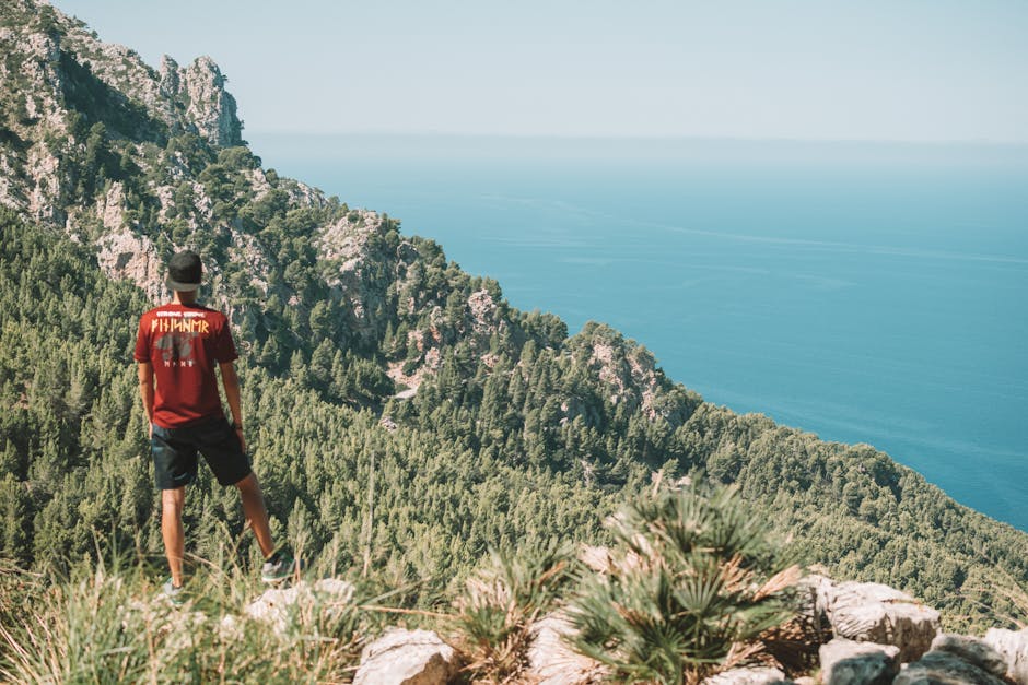 A man enjoying the breathtaking coastal view from the mountains in Mallorca, Spain.