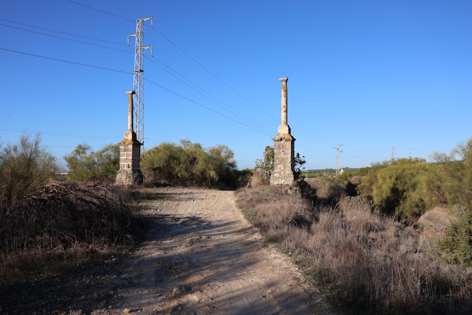 Two ancient columns stand on a historic path in El Puerto de Santa María, Spain.