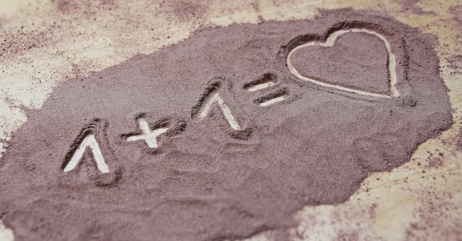 Equation written in sand with 1+1 equals heart. Expresses love and creativity.