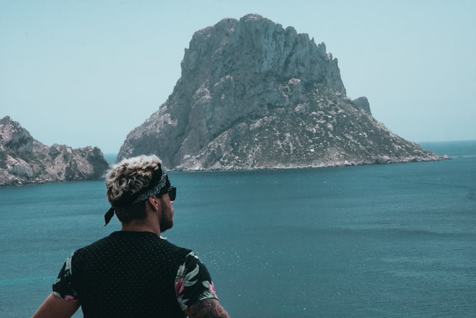 A man with a bandana observes the iconic rock island Es Vedrà from Sant Josep de sa Talaia, Ibiza.