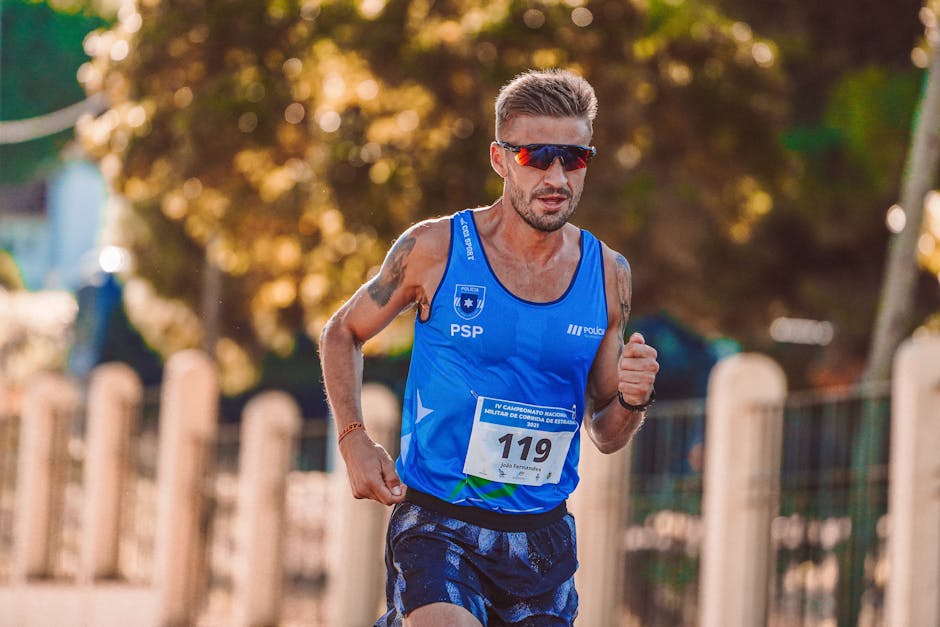 Athletic male runner wearing sunglasses participates in an outdoor race on a sunny day.