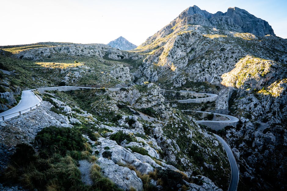 Winding road through rugged mountain landscape under clear sky
