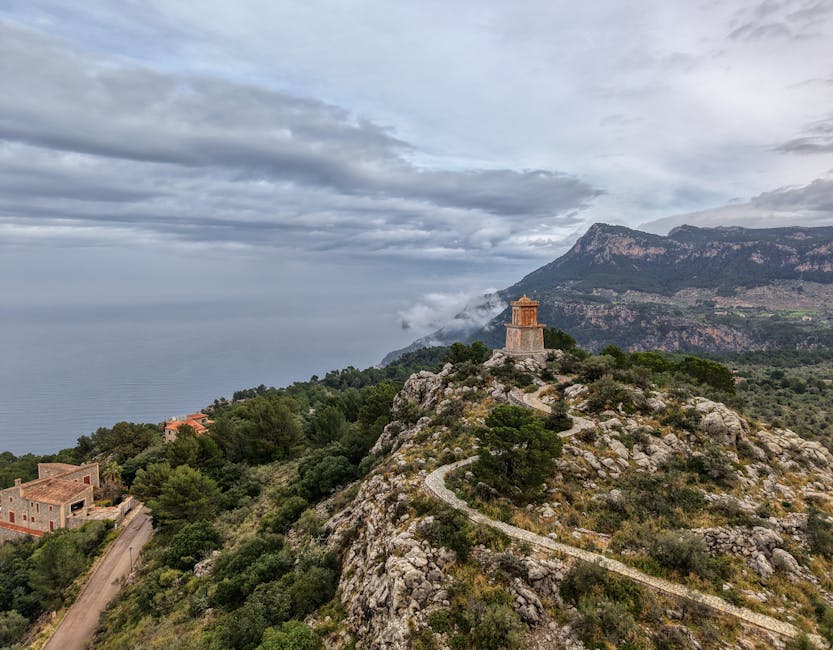 Stunning view of the rocky coastline and lush greenery of Mallorca, Spain, under a cloudy sky.