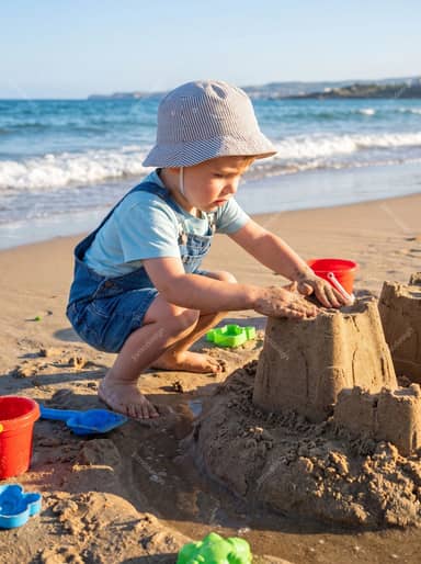 Child Building Sandcastle On Sunny Beach