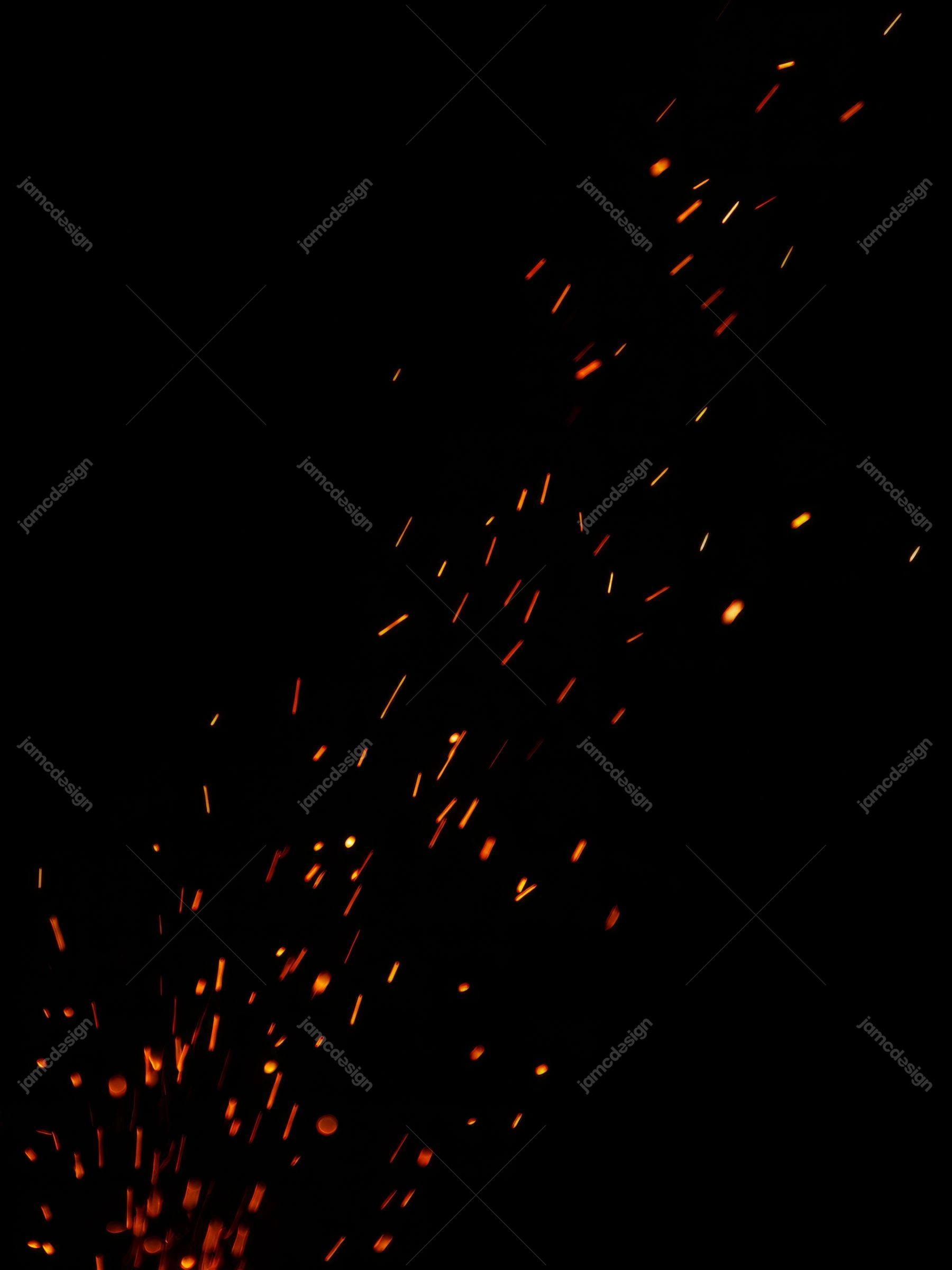 Glowing Orange Ember Sparks Rising On Black Background Texture. JPG texture showing glowing orange and red ember sparks rising through a deep black background