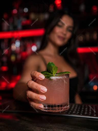 Pink Drink Bartender Offering Craft Cocktail In Red Lit Bar Photo JPG