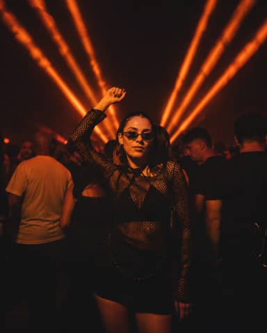 Young Woman Dancing in Nightclub with Orange Laser Lights Photography