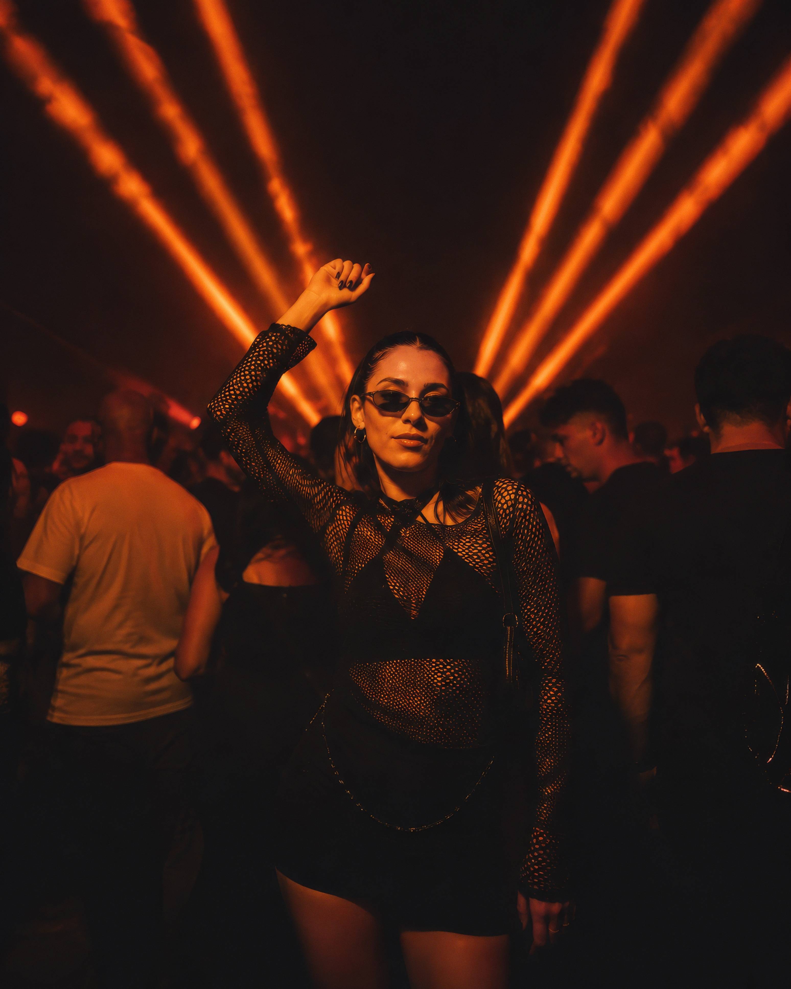 Young Woman Dancing in Nightclub with Orange Laser Lights Photography