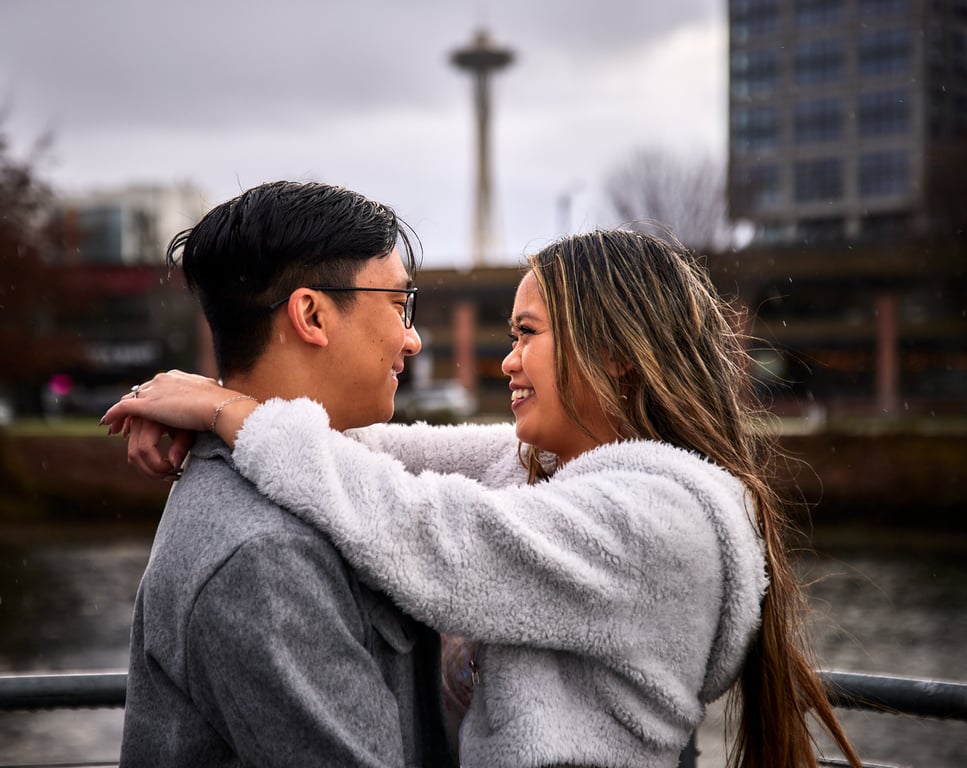 Couple posed together with lush greenery framing the background