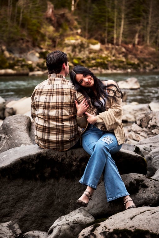 Couple laughing together within a sunlit forest clearing