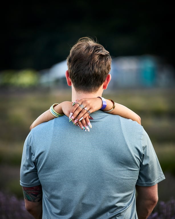 Couple posed together in a lush green outdoor setting