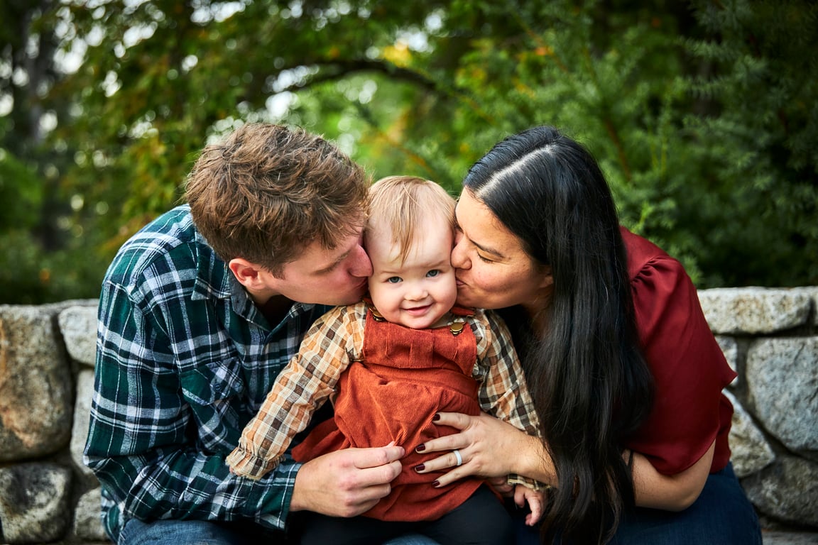 Family posed together with lush natural greenery behind them