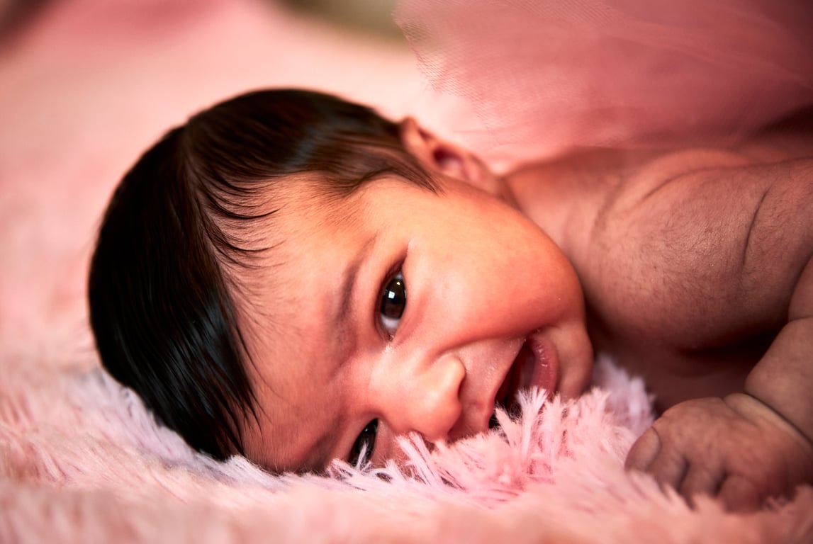 Newborn close-up highlighting delicate fingers and features