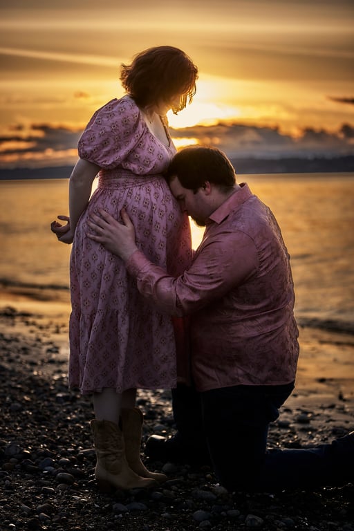 Maternity couple posed together in a warm golden glow