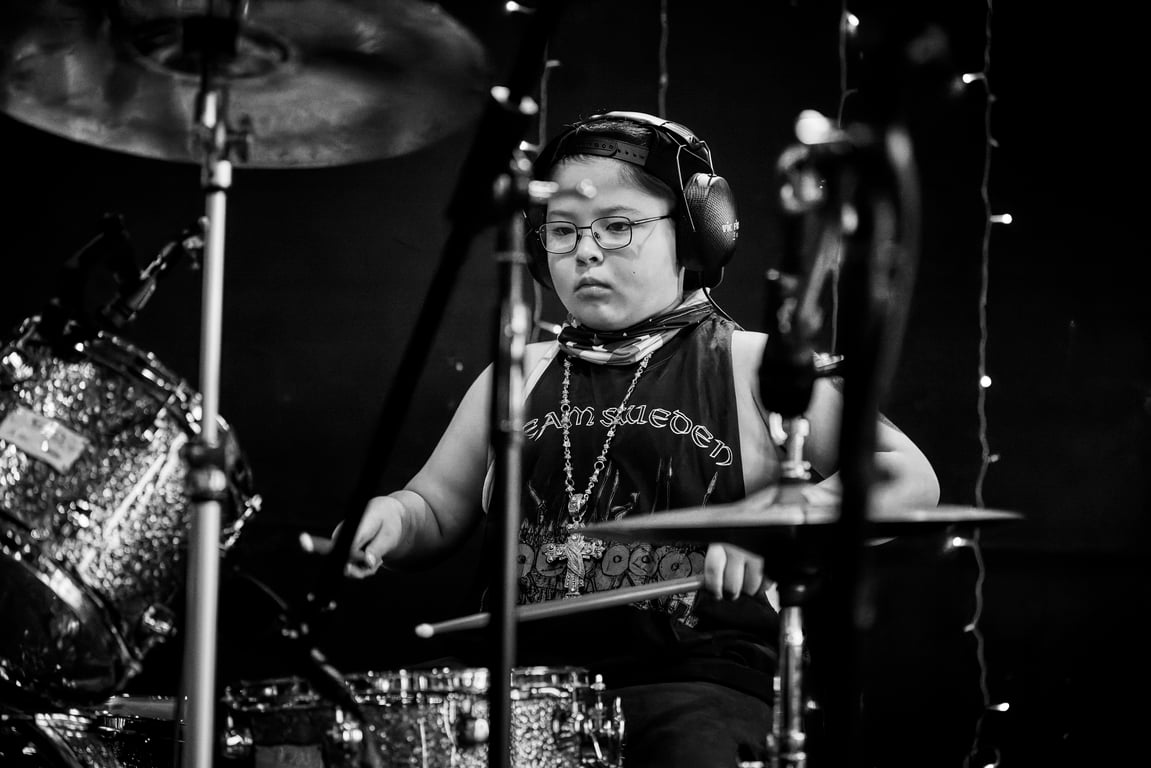 Drummer performing on stage during a live music recital