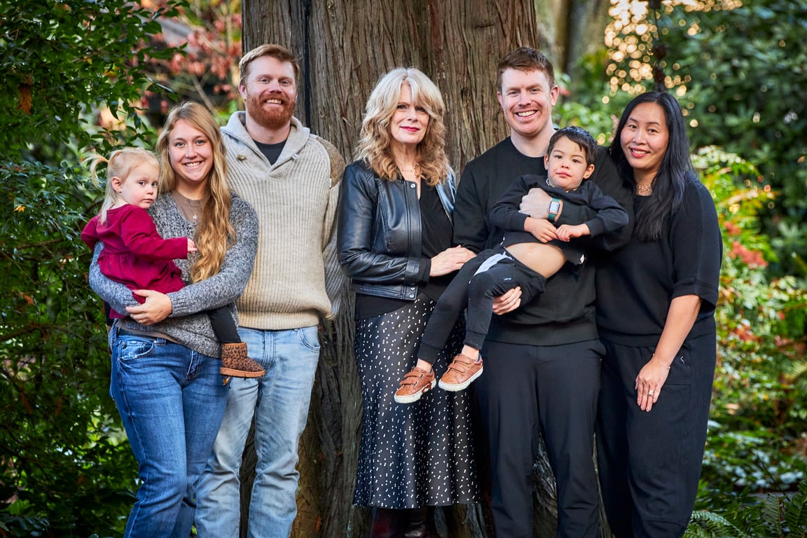 Family standing close together with warm welcoming smiles