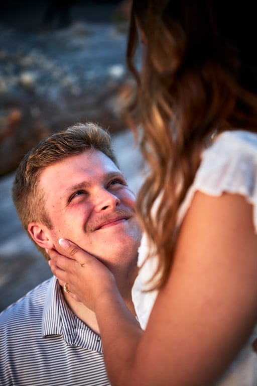 Golden light filtering through trees during an outdoor couples embrace