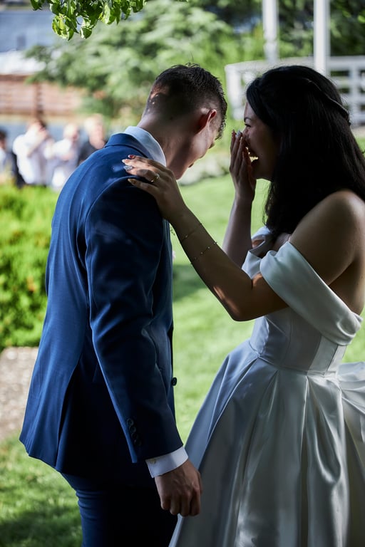 Newlyweds embracing with the wedding venue framed behind them