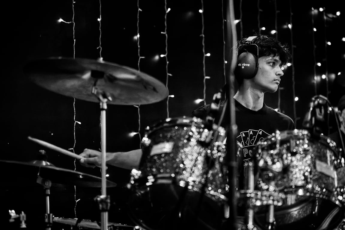 Drummer caught in an energetic performance sequence