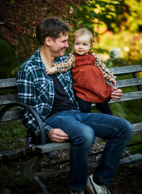Family gathered close together with a lush natural backdrop