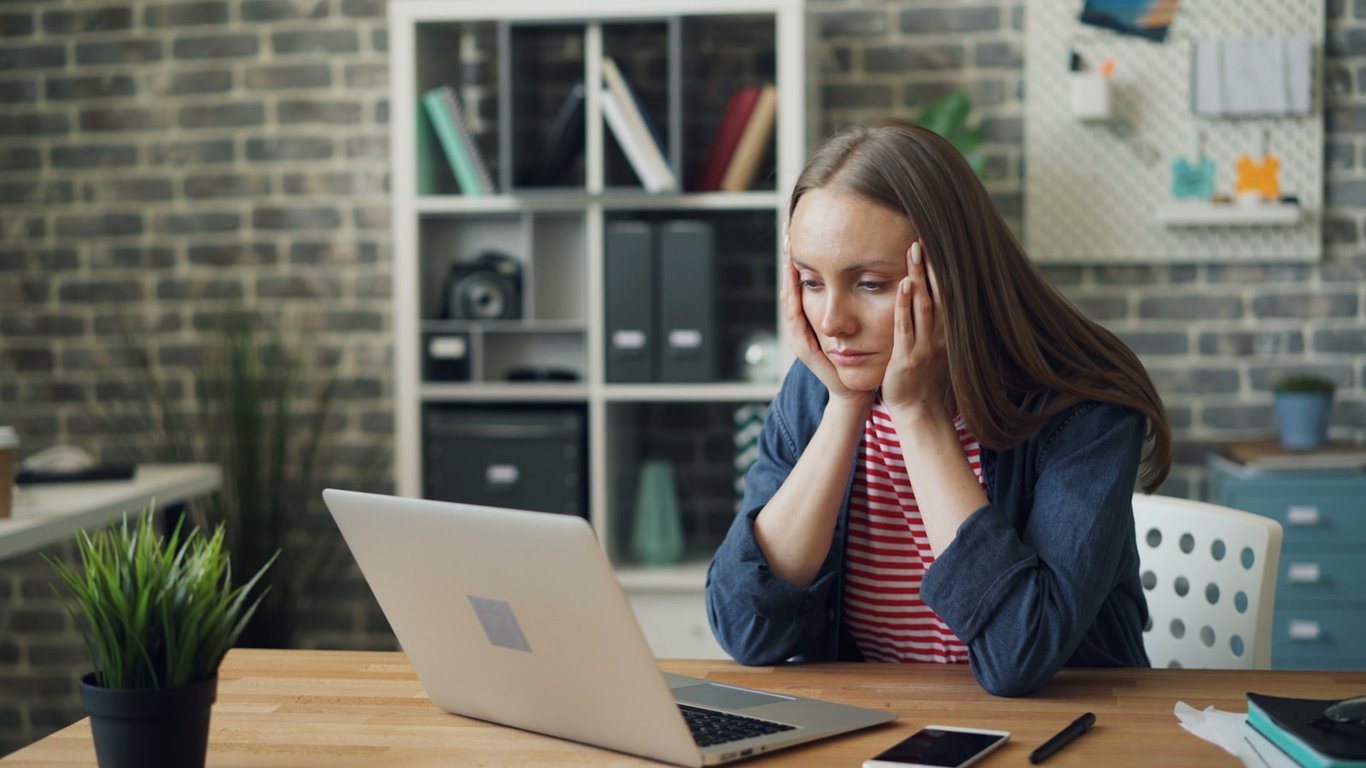 Student sitting at a table with a laptop, working through coursework
