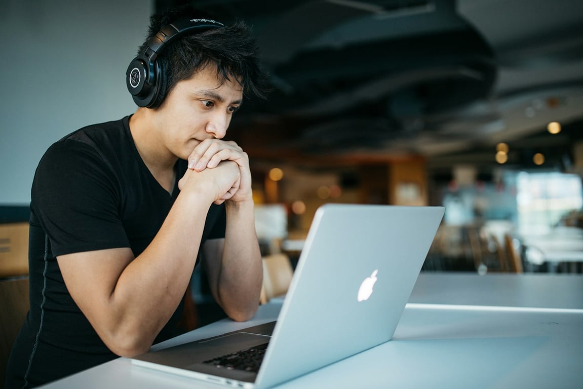 Student wearing headphones working on a laptop