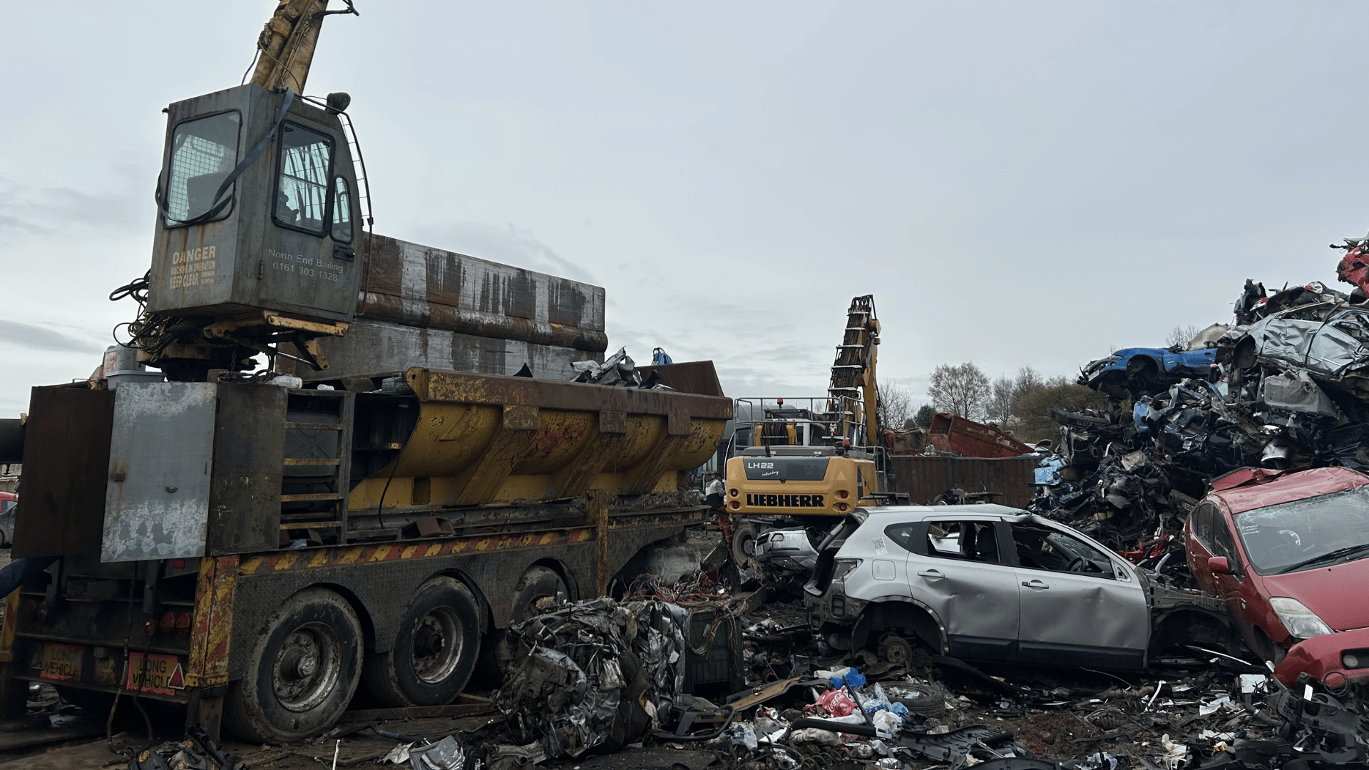 Scrapyard with crane and crushed cars