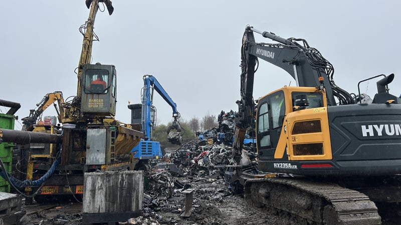 Excavators sorting scrap metal at recycling yard