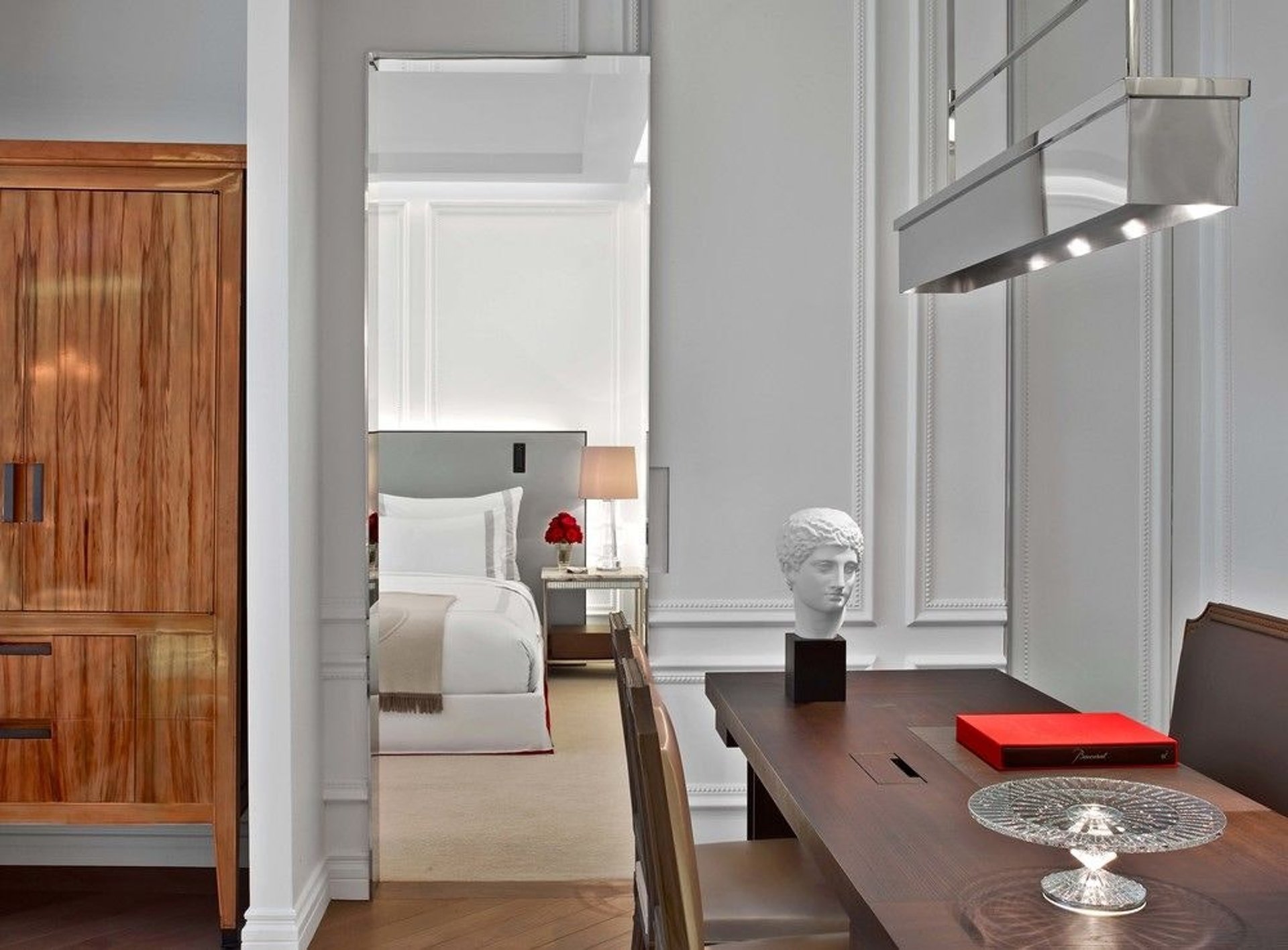 A Manhattan suite dining table with a marble bust, the bedroom beyond