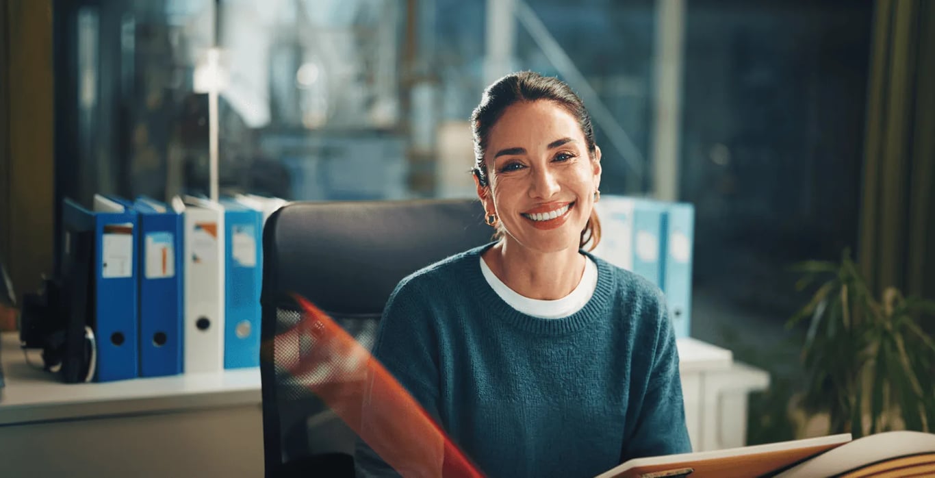 Smiling clinician at her desk in a records office