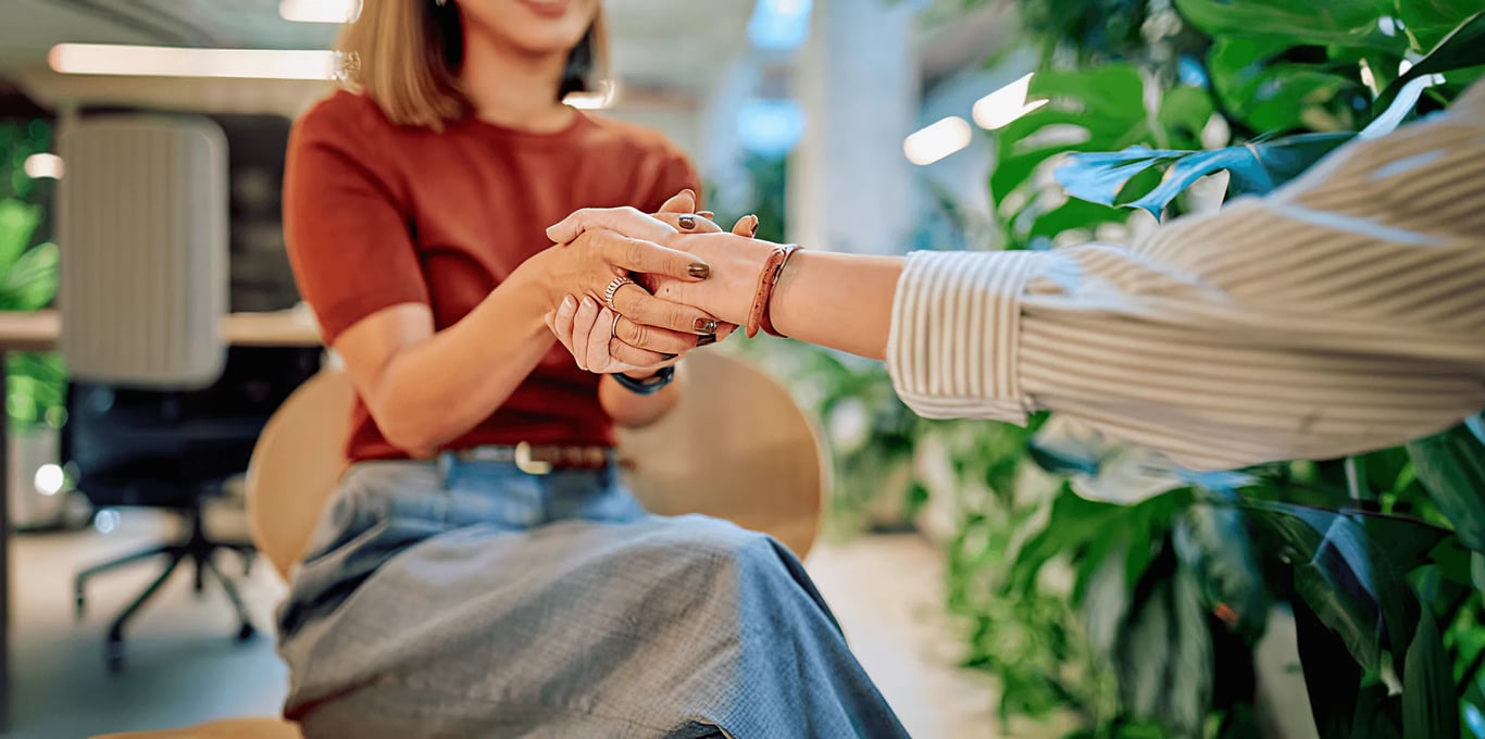 Two people holding hands in conversation