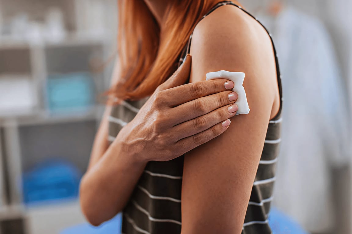 Woman pressing a cotton pad to her arm after a blood draw