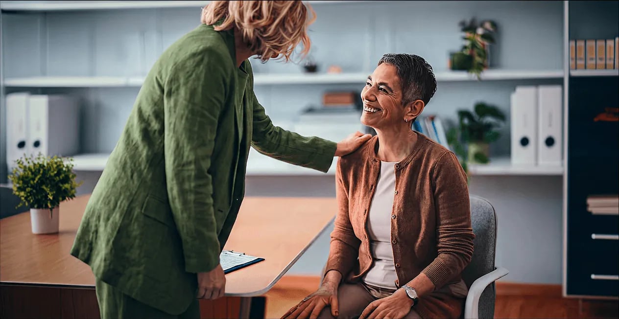 Clinician greeting a smiling patient in her practice