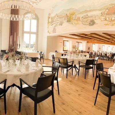 Festlich gedeckter Löwen-Saal mit Wandgemälde in historischem Stil.