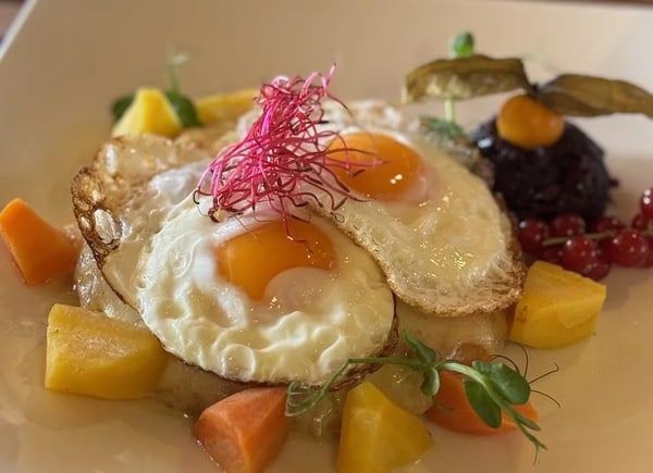 Fried eggs on rösti with colorful winter vegetables.
