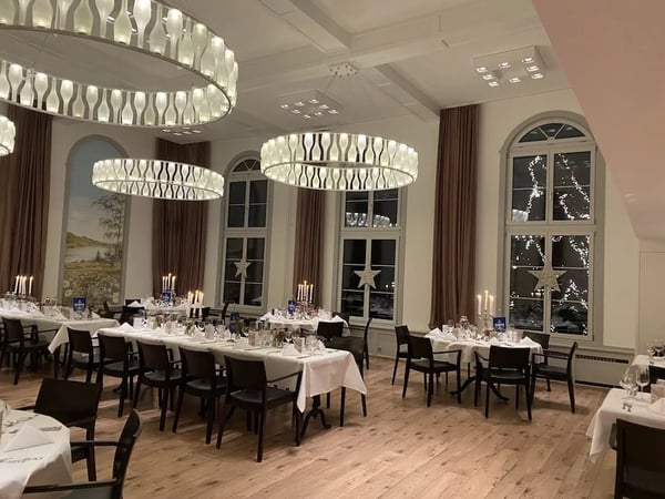 Many lamps and candles create a Christmas ambiance in the Löwen hall. The Löwen Christmas tree shines through the window.