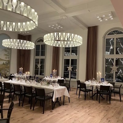 Many lamps and candles create a Christmas ambiance in the Löwen hall. The Löwen Christmas tree shines through the window.