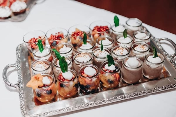 Small dessert glasses on a beautiful silver platter.