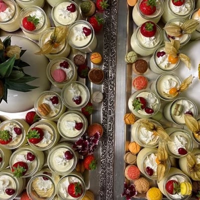 Festlich angerichtetes Dessert-Buffet mit Crèmes und Mousses in Weck-Gläsern, dekoriert mit Ananas und Orchideen.